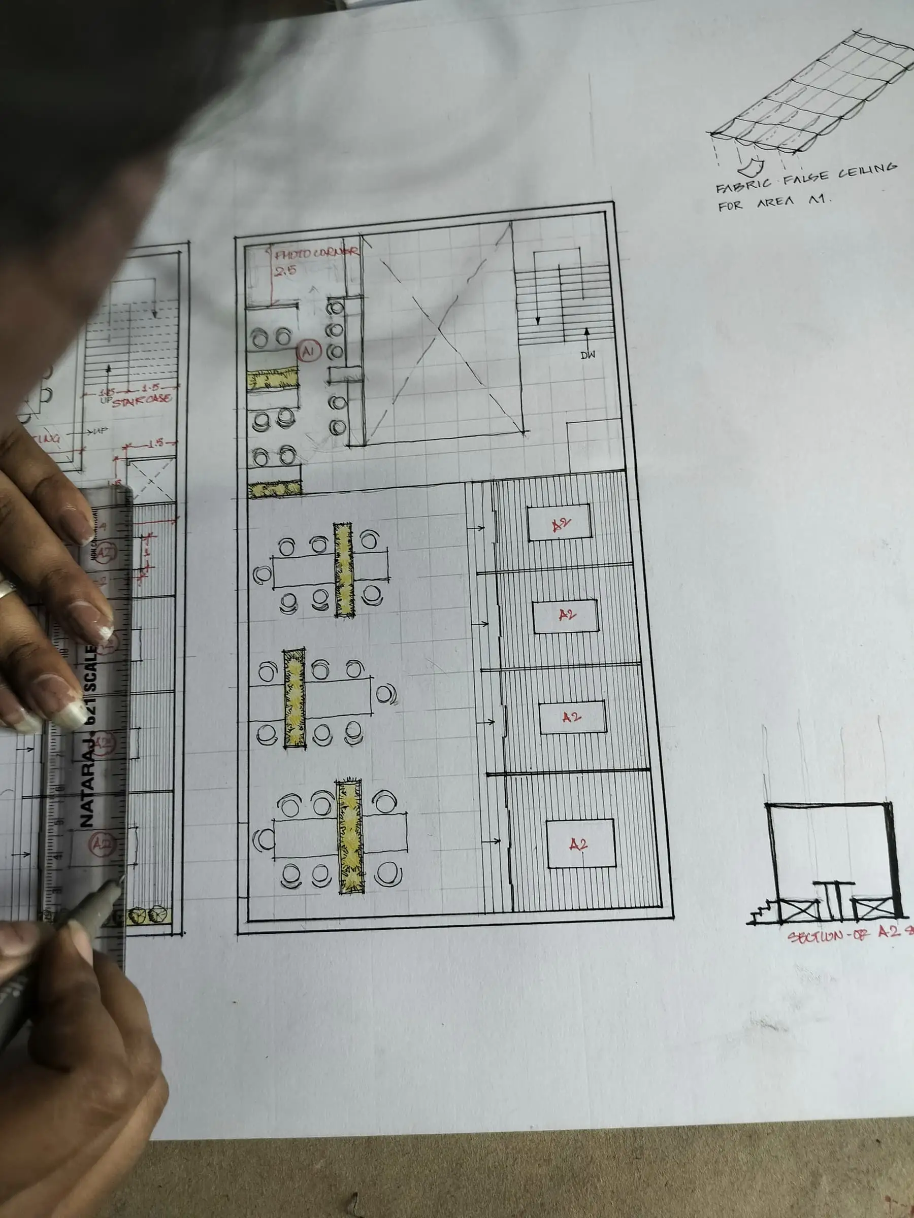 A floor plan being drawn in pencil on a white sheet.