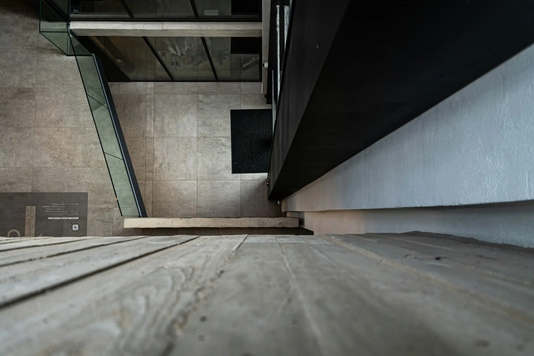 A view along a concrete ledge above a pale tiled floor.