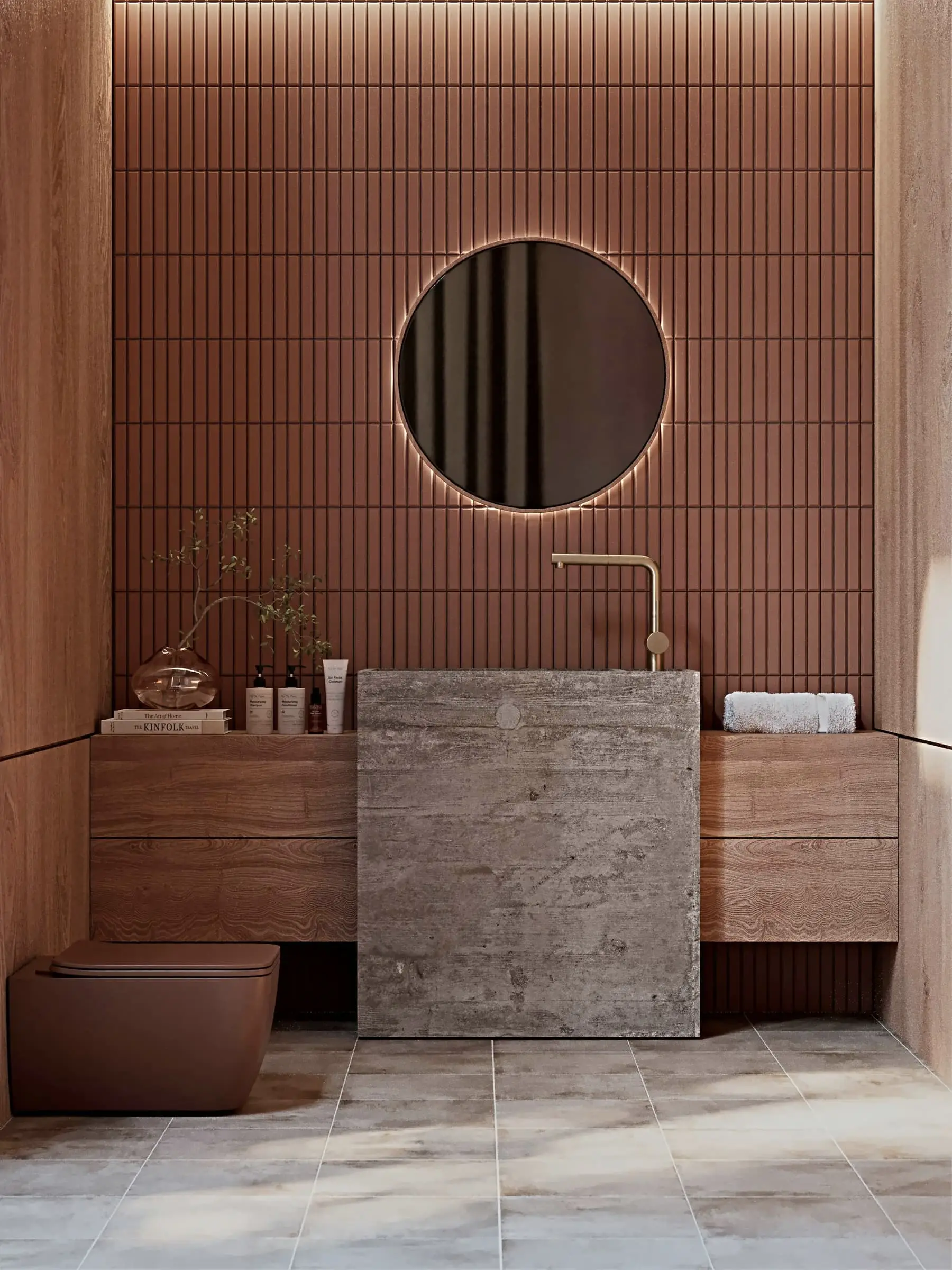 A bathroom with terracotta wall tiles, a stone basin and a round mirror.